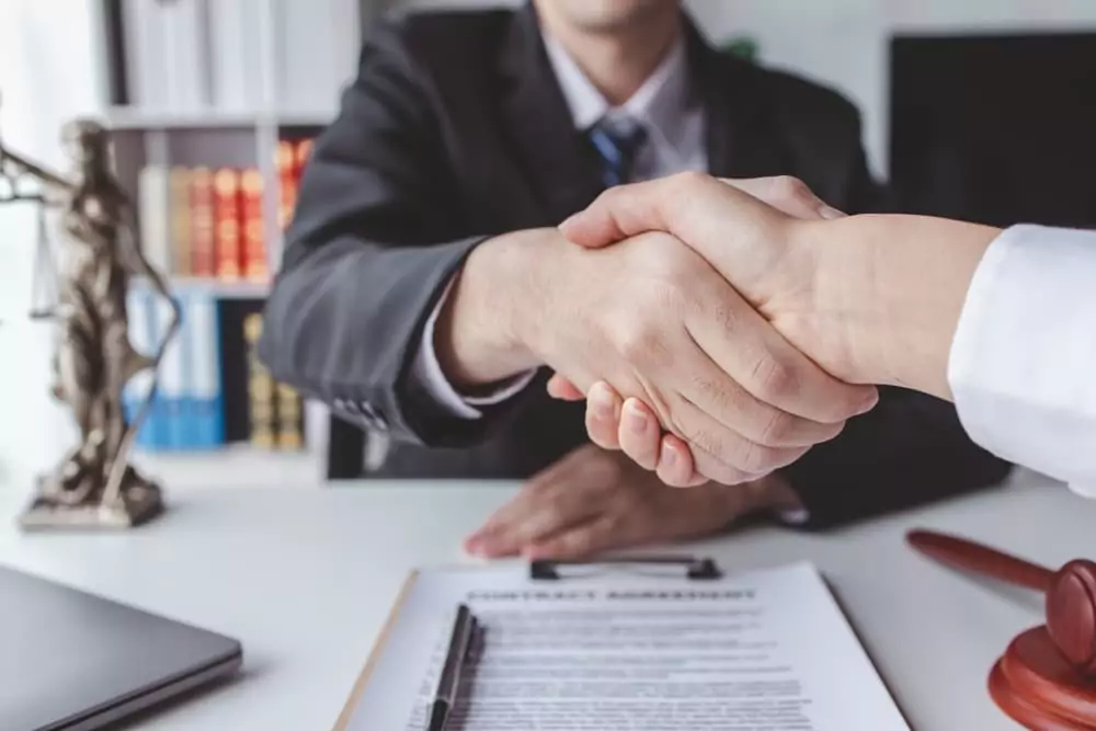 Professional agreement: Businessman shakes hands with a lawyer or judge post-contract signing, confirming a completed deal.