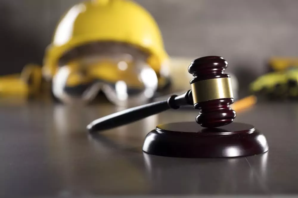 A gavel and construction safety gear, representing the enforcement of California labor laws for in-state and out-of-state workers.