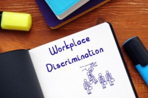 Workplace Discrimination with phrase on the piece of paper.
