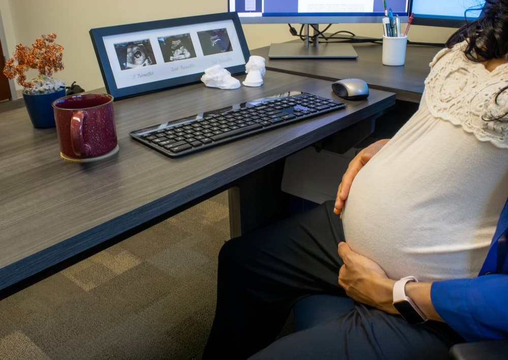 A Pregnant Lady sitting in front of a desk