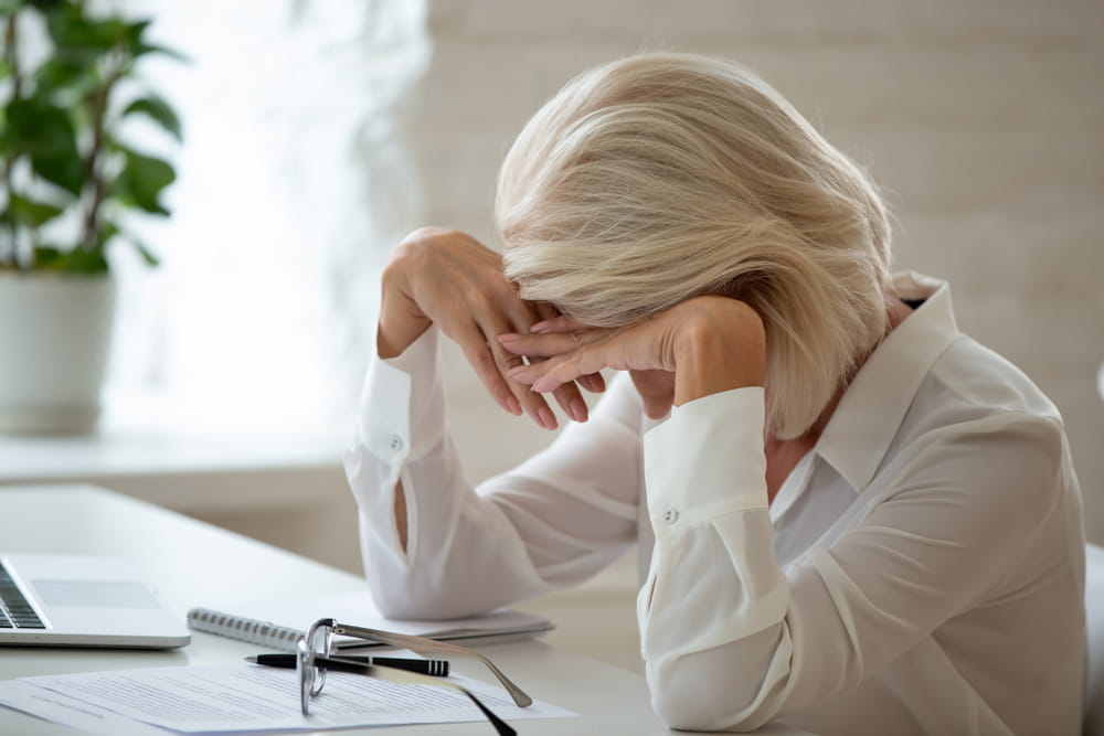 Older employee experiencing stress at work due to potential age discrimination in California
