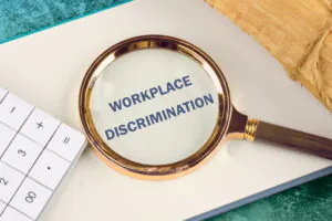 Magnifying glass highlighting workplace discrimination concept in California employment law