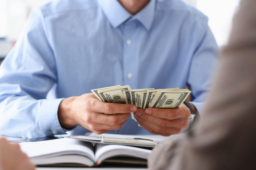 Employee counting cash representing unpaid wages overtime or missing compensation in San Diego workplace