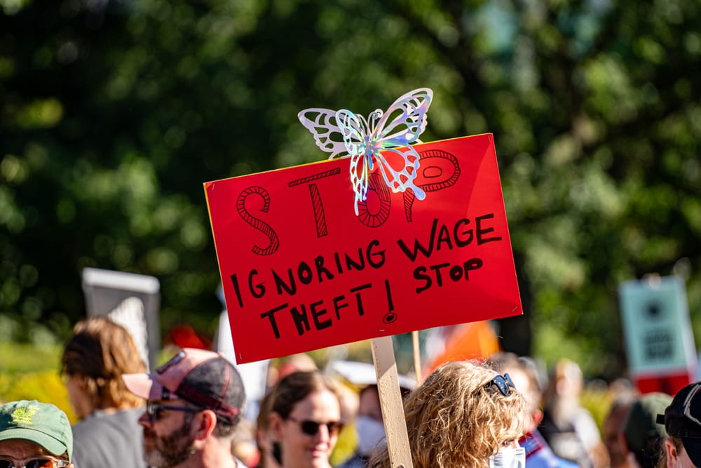 Protest sign against wage theft representing workers rights violations and unpaid wages in San Diego