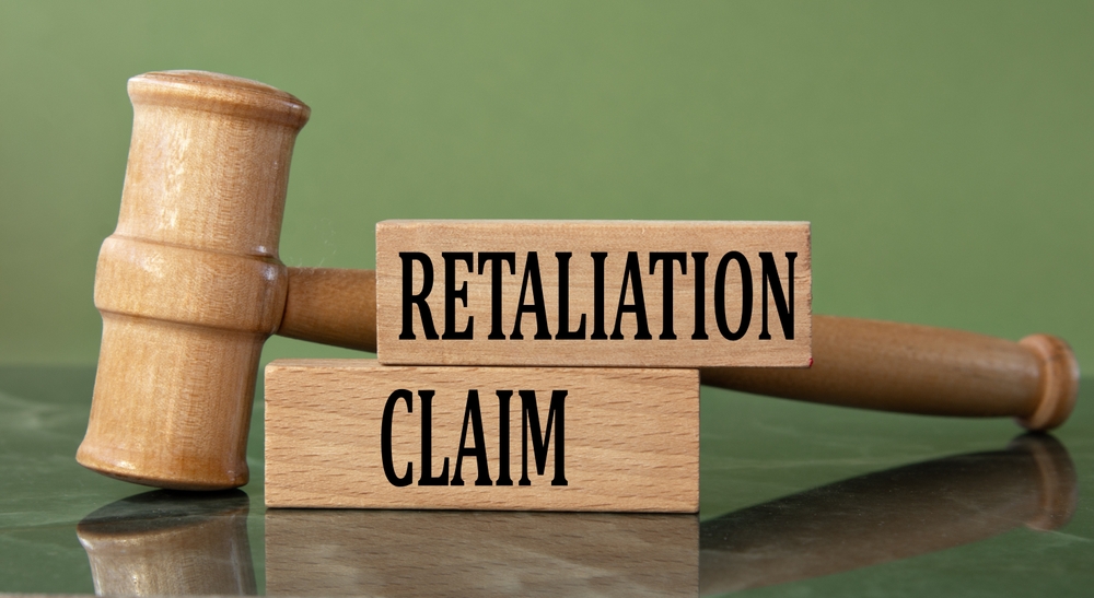 RETALIATION CLAIM - words on wooden blocks with a judge's gavel in the background